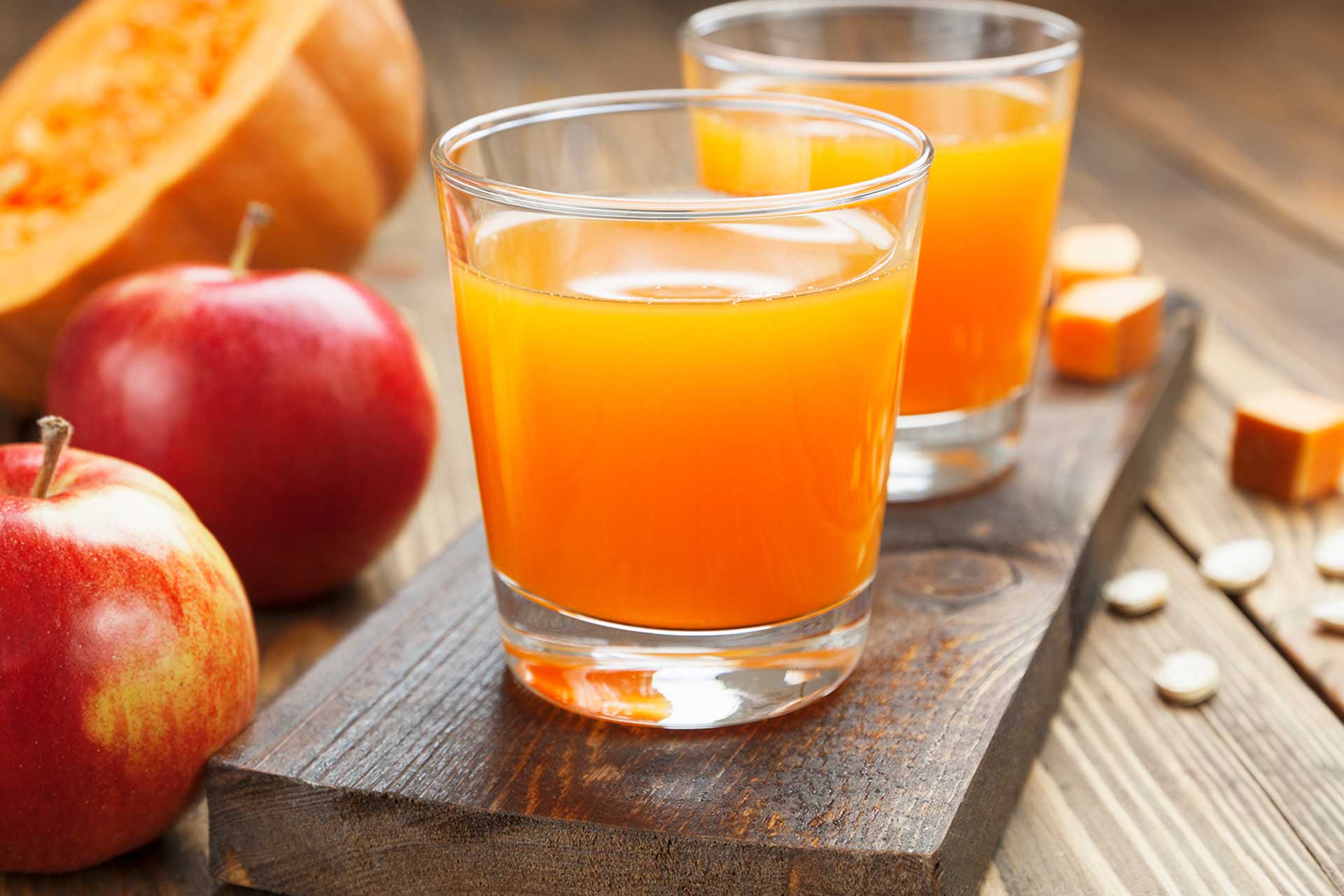 orange juice on wooden board with apples