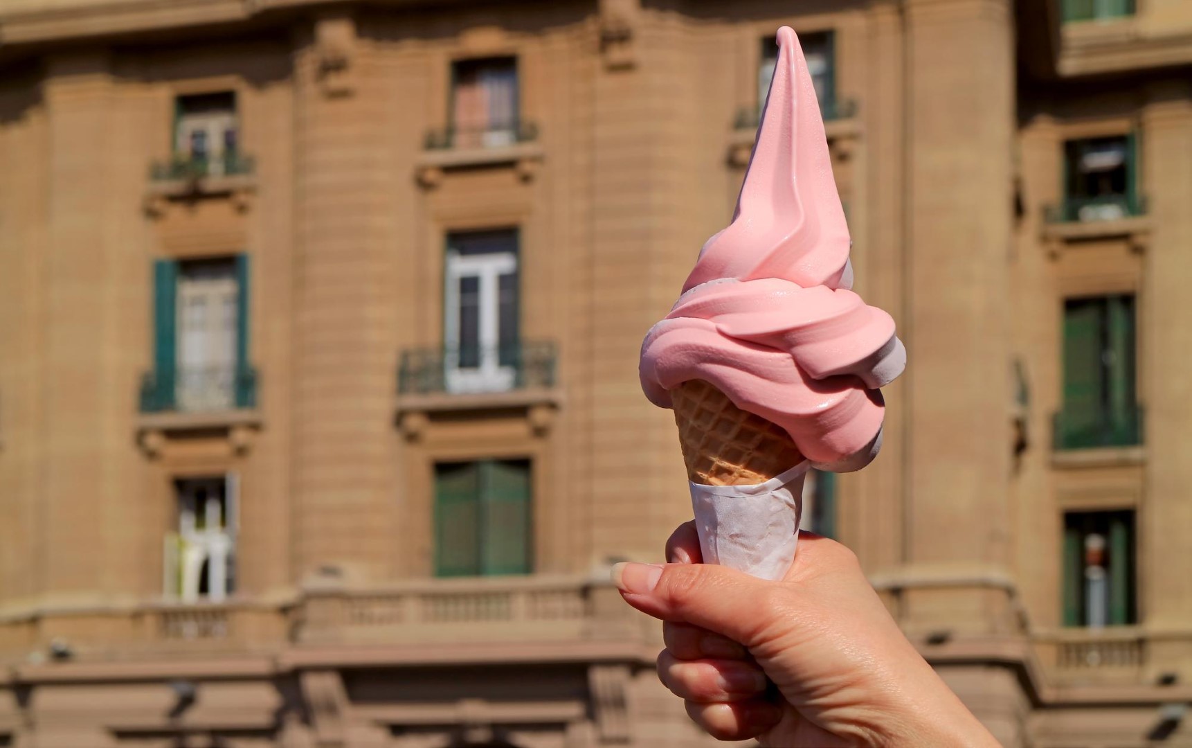 Woman outdoor  at summer sunset time having ice cream cone positive happy playful at city street