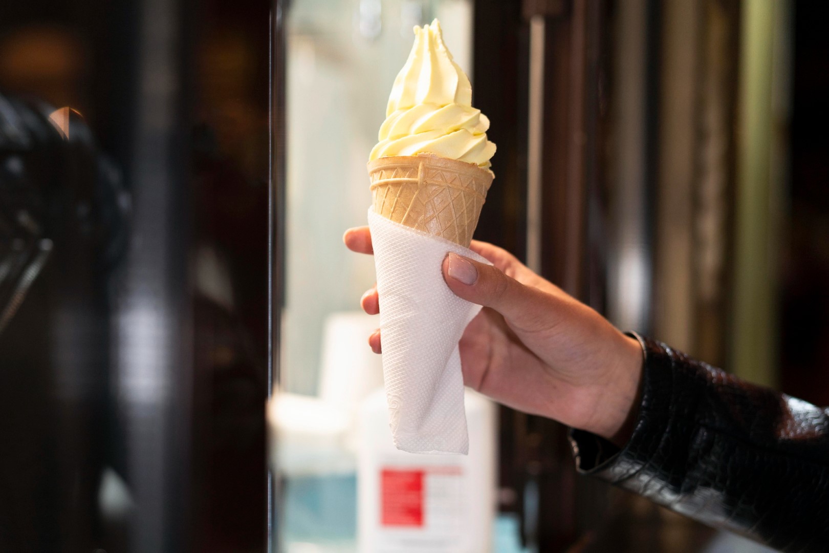 Woman outdoor  at summer sunset time having ice cream cone positive happy playful at city street